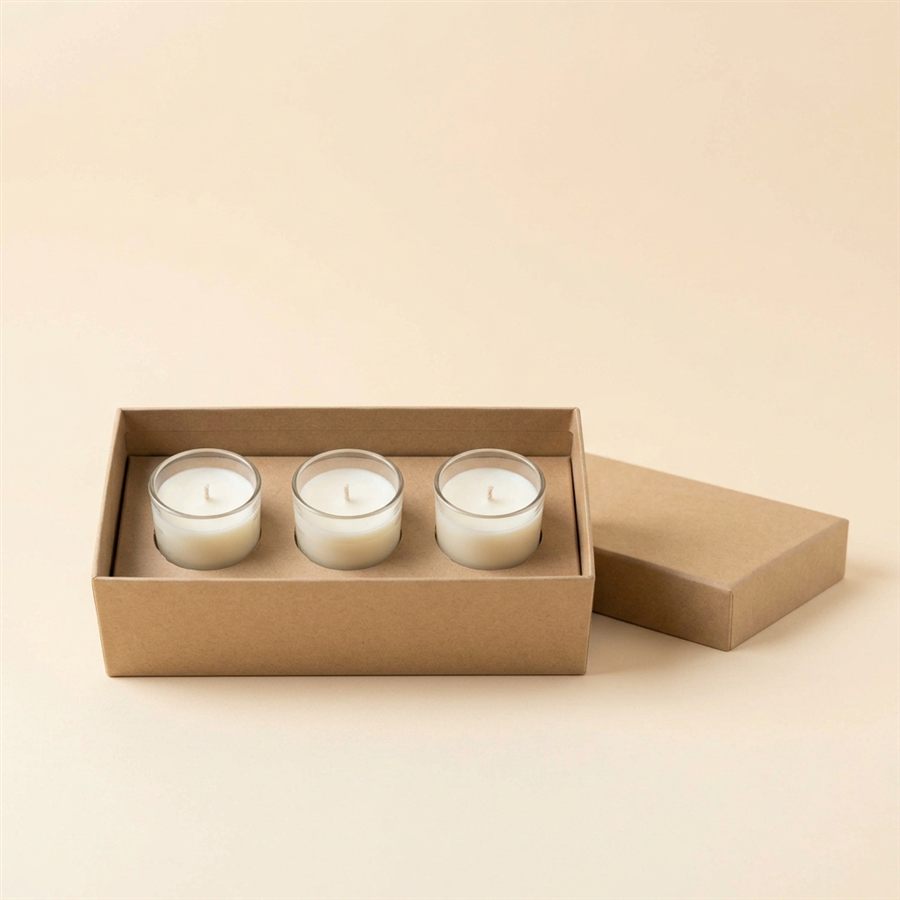 A gift box holding three small candles with its lid open beside it